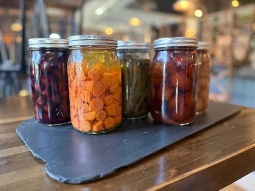 jars of pickles on a slate tablet on a table